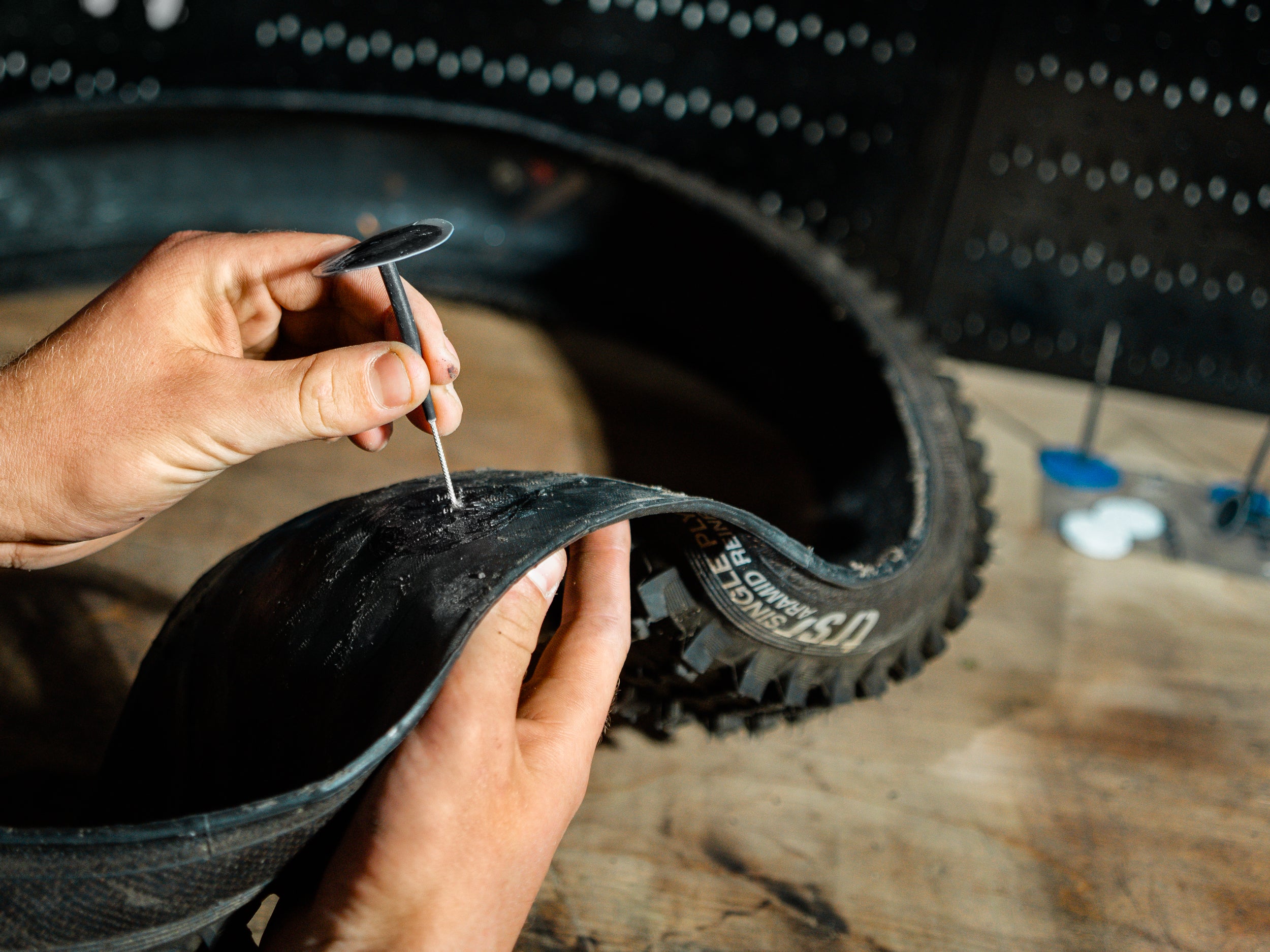 Premium tubeless bike tire plug Lezyne Tubeless Pro Plugs inserted into a punctured tire to prevent air leaks.