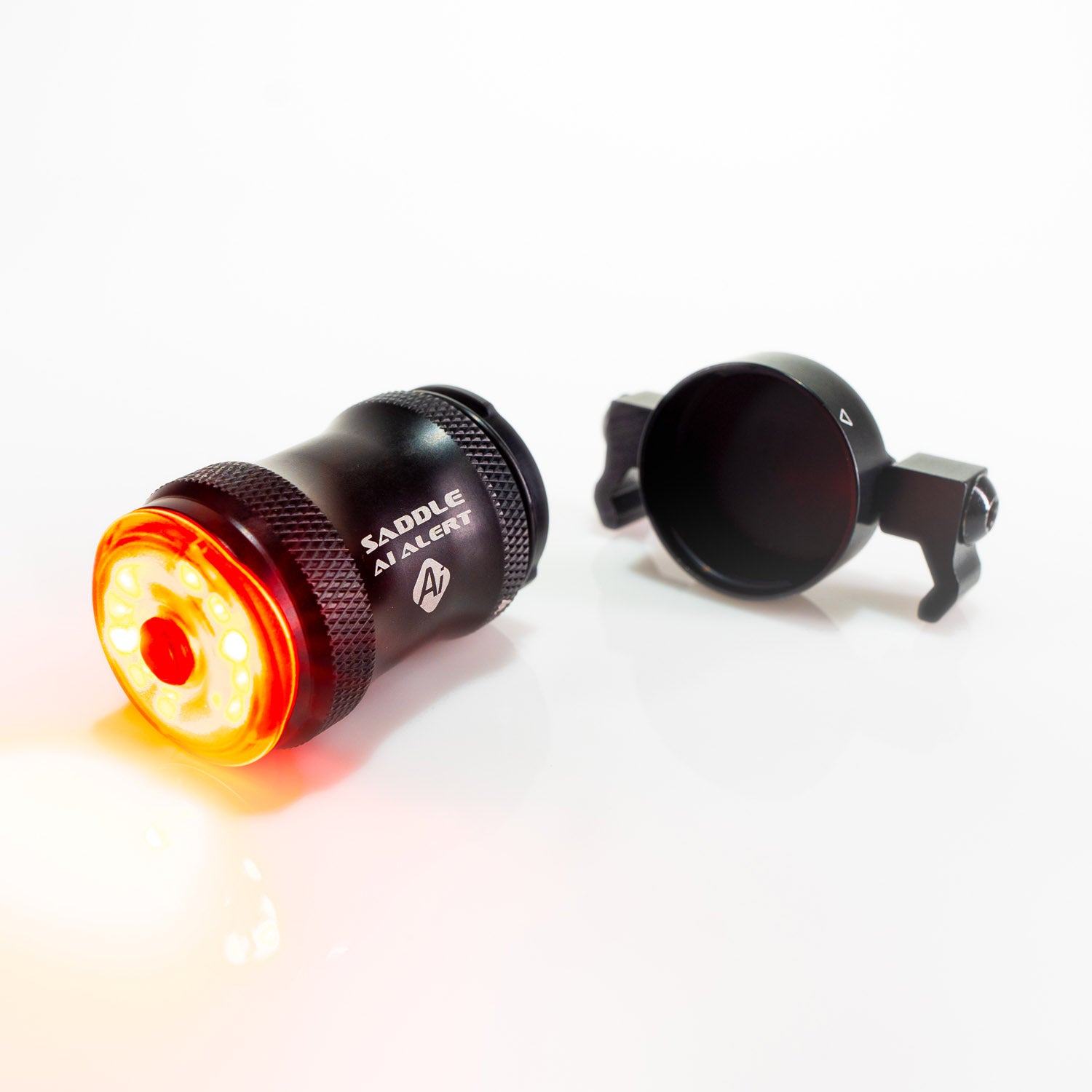 SADDLE Ai ALERT 250 REAR bike light illuminated, back cap detached to reveal waterproof USB-C charging connection.