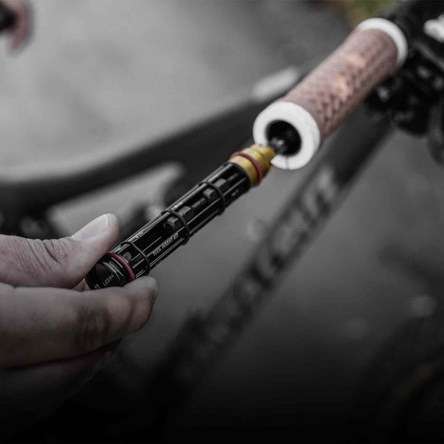Someone removing a tool from inside bicycle handlebars.
