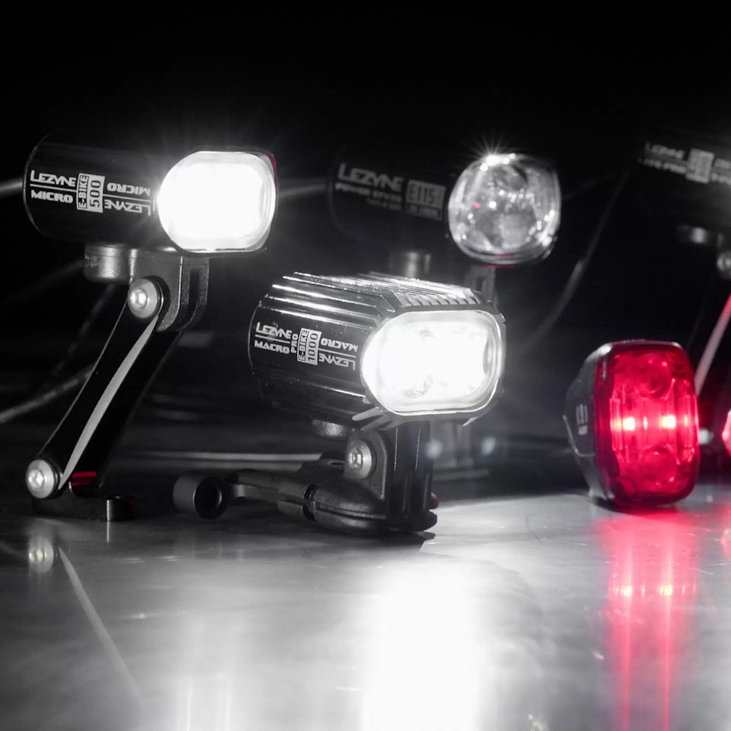 Several lights on a surface. Lezyne Micro E-Bike 500 can be seen printed on the side of one of them.