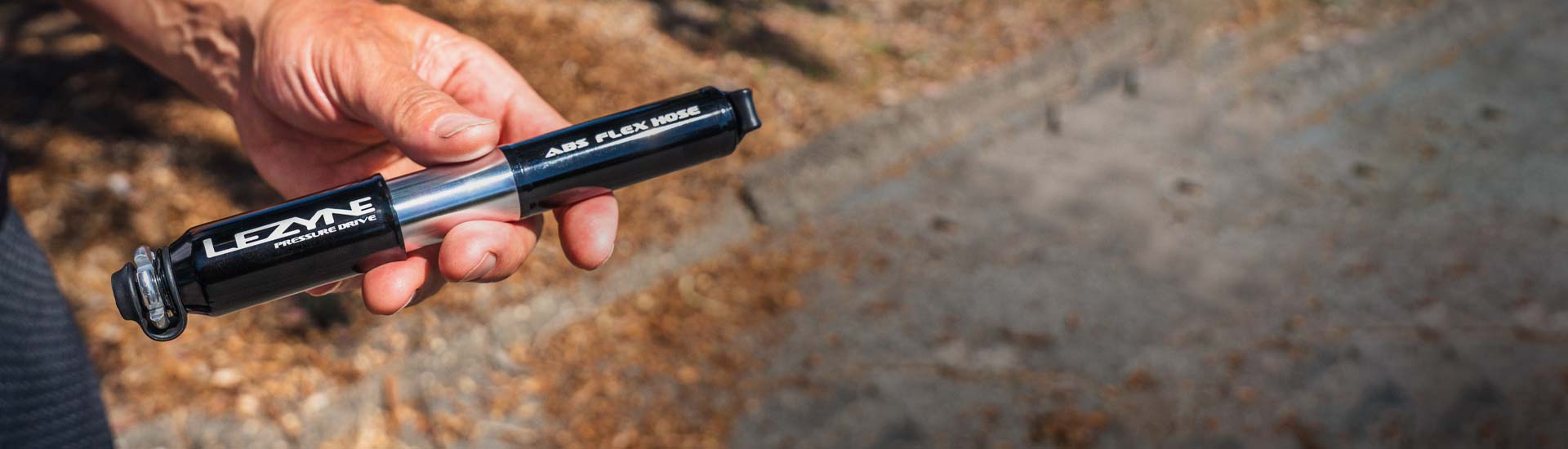 Close-up of Lezyne hand pump designed for efficient and portable tire inflation on road bikes.