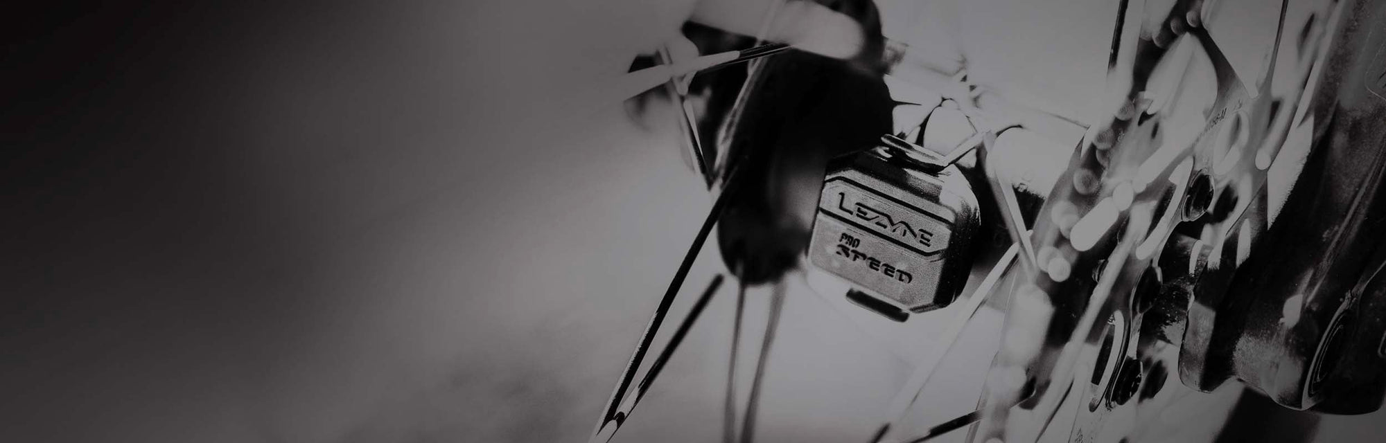 A sensor with the words Lezyne Pro Speed printed on it mounted to a bicycle wheel axle..