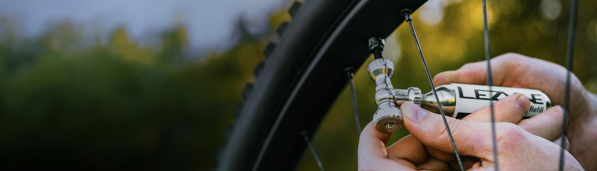 A CO2 tire inflation canister near some bicycle tire spokes.