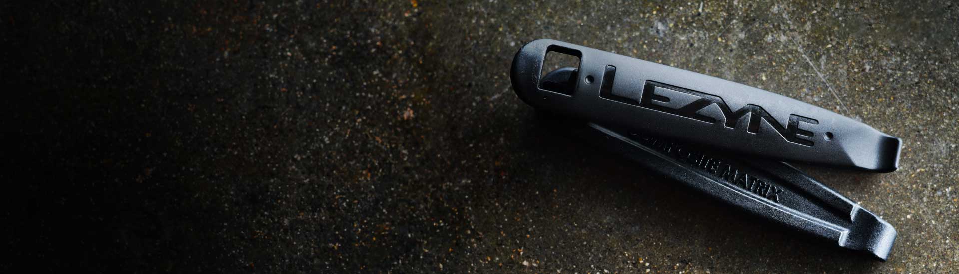 A close up of a tire lever with the word Lezyne printed on it.