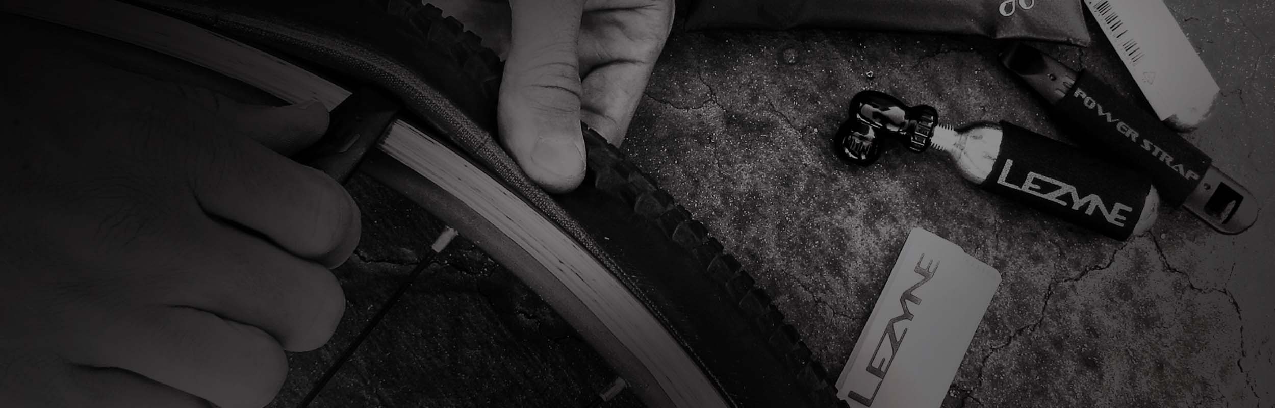 Someone using a tool to remove a bicycle tire from a rim.