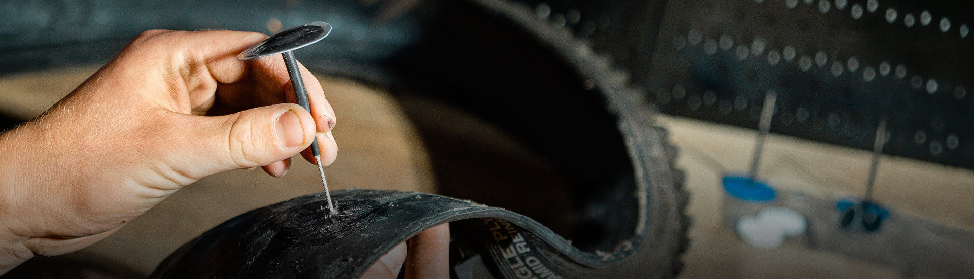 Someone using a tool to remove a bicycle tire from a rim.