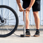 Lezyne Alloy Floor Drive 3.5 floor pump in use outdoors next to a bicycle tire