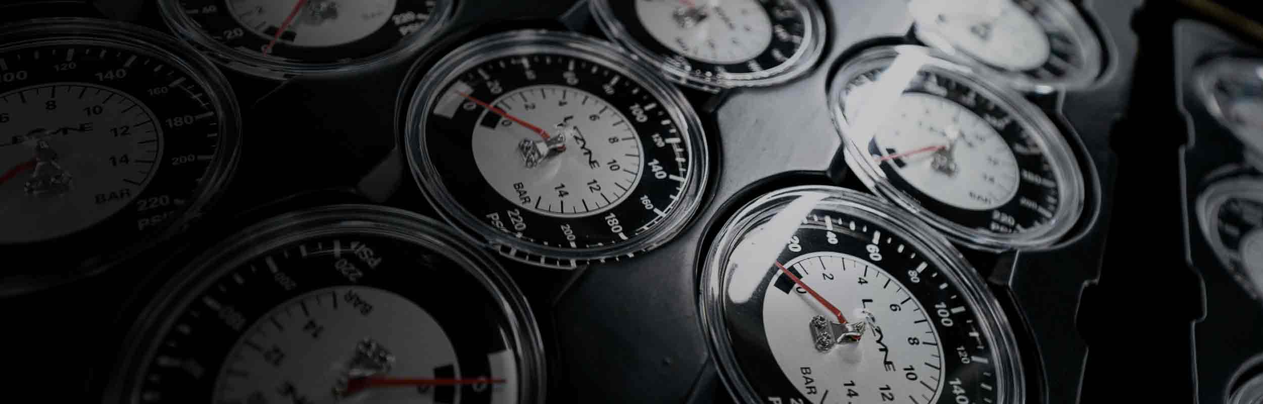 Several analog pressure gauges arranged in a grid. 