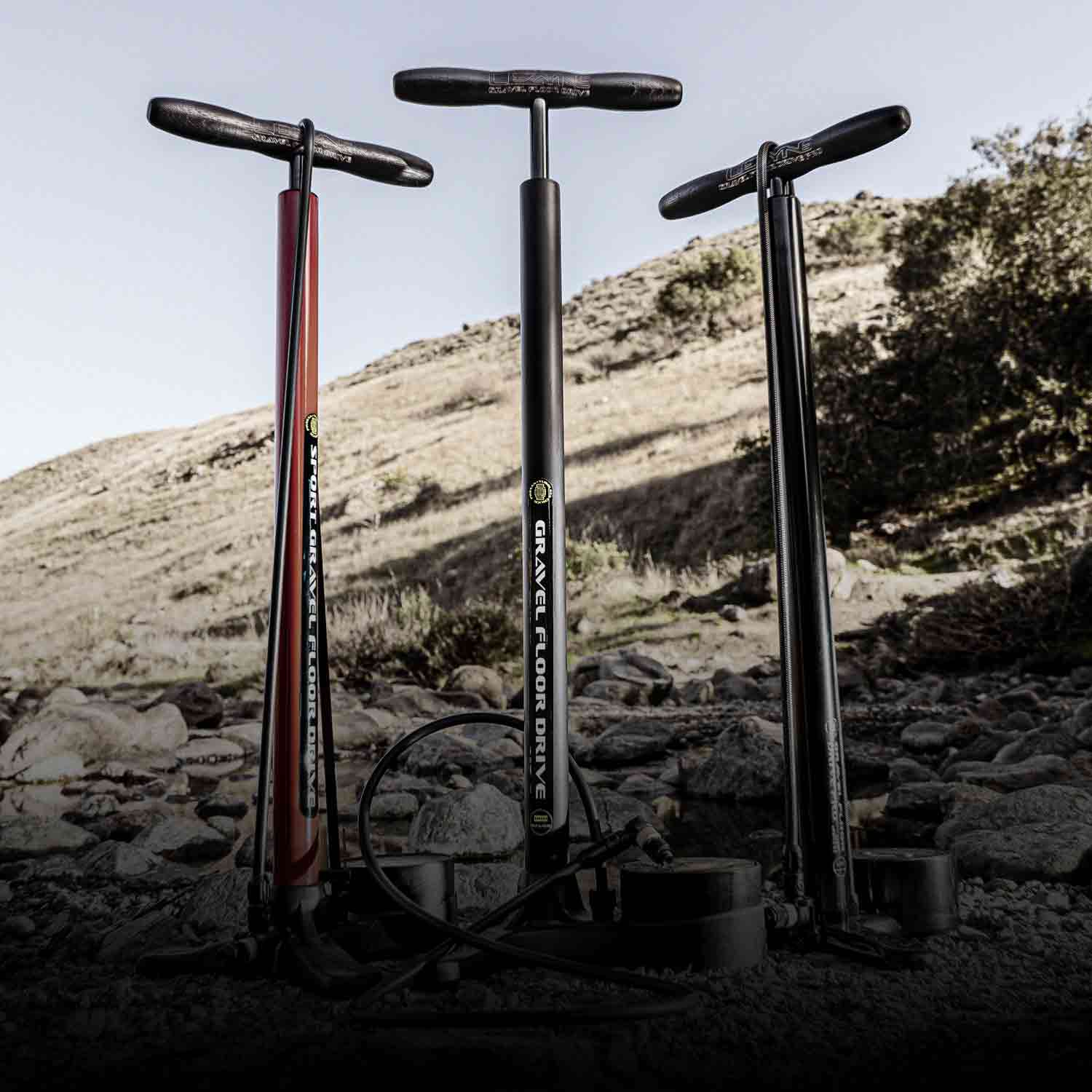3 Floor pumps on a rocky hillside with the words Gravel Floor Drive printed on one of them.