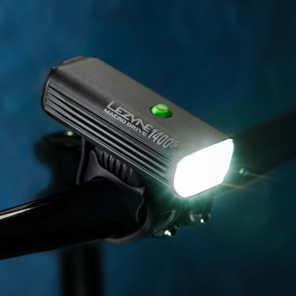 Profile view of the MACRO DRIVE 1400+ front LED bike light mounted on road bike handlebar, ideal for cycling after sunset.