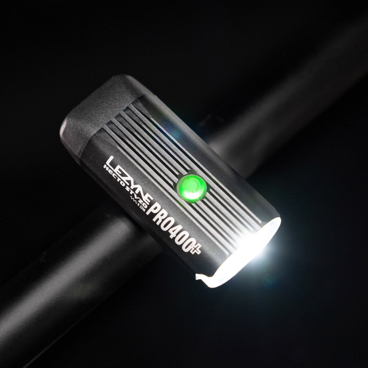 Bird's-eye view of the Lezyne Hecto Pro StVZO 400+ LED front light, with a green circular power light on top of housing, mounted on handlebars.