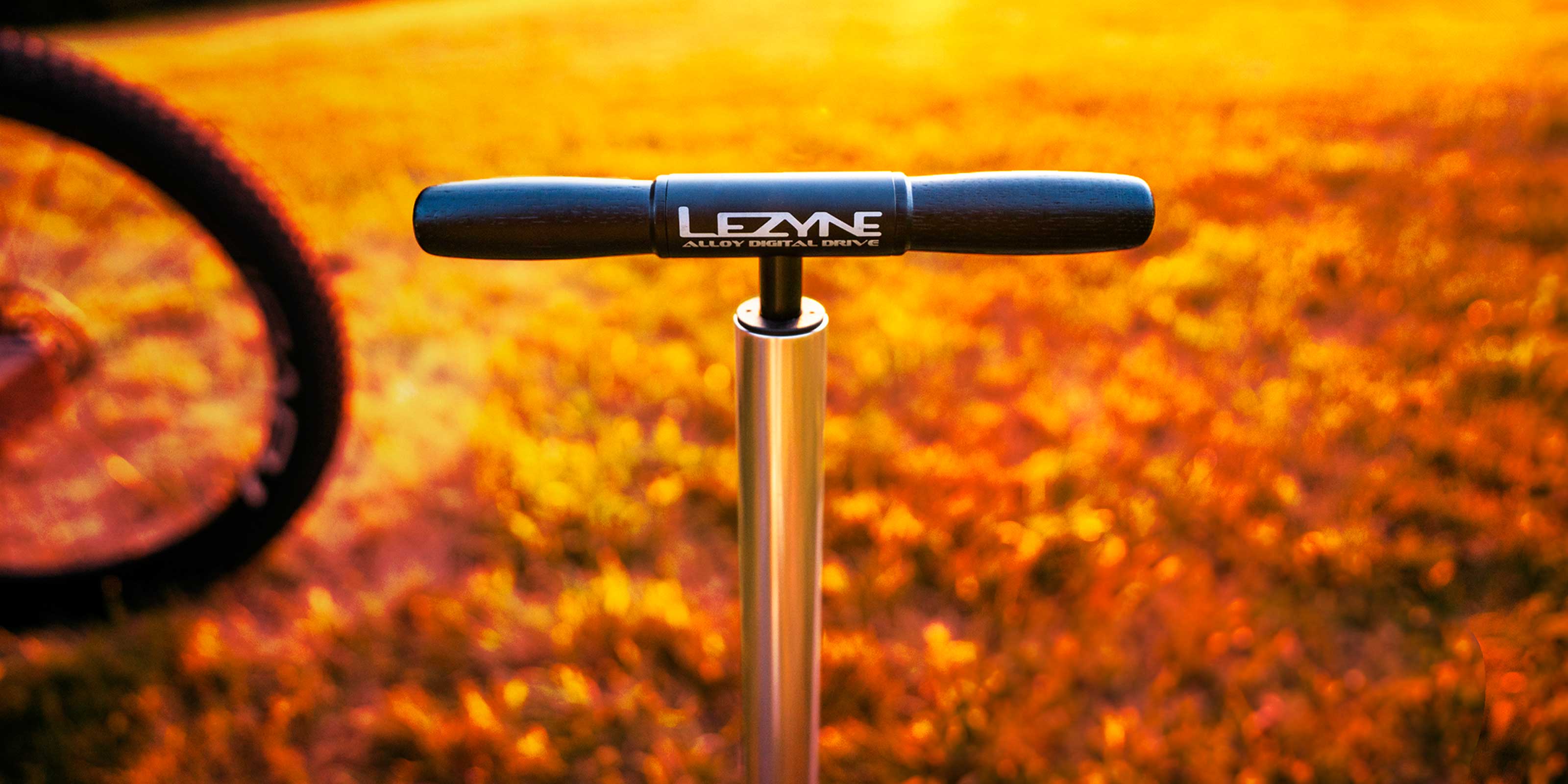 Lezyne floor pump handle against golden sun-drenched grass