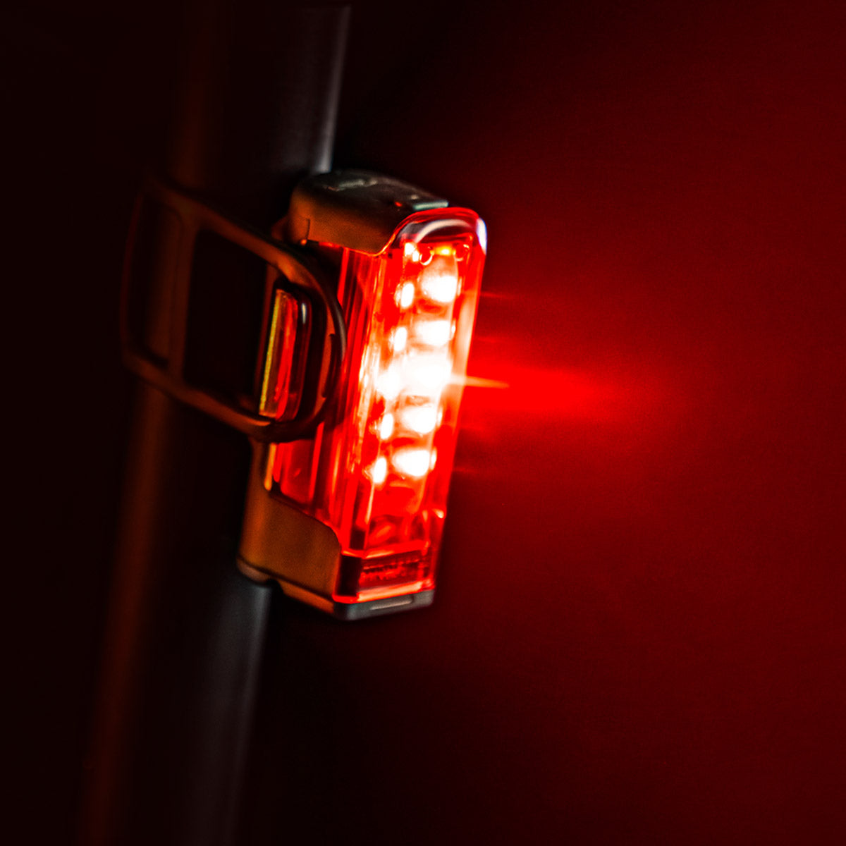 Side view of bestselling STRIP DRIVE 300+ REAR LED bike light, mounted on a road bike seat post, emitting a powerful red light.