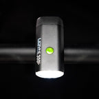 Top-down view of the Lezyne Micro StVZO 300+ headlight with a green lit power button on top of the housing, mounted on the bike handlebars.