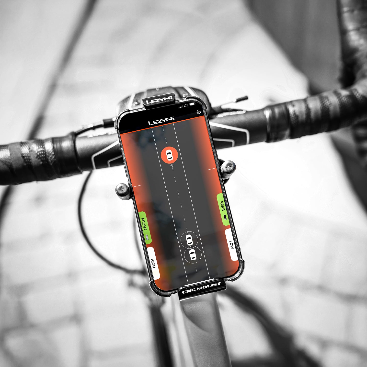 Lezyne Radar StVZO Rear paired with Radar App — phone screen shows live vehicle alerts and mode controls for safety.