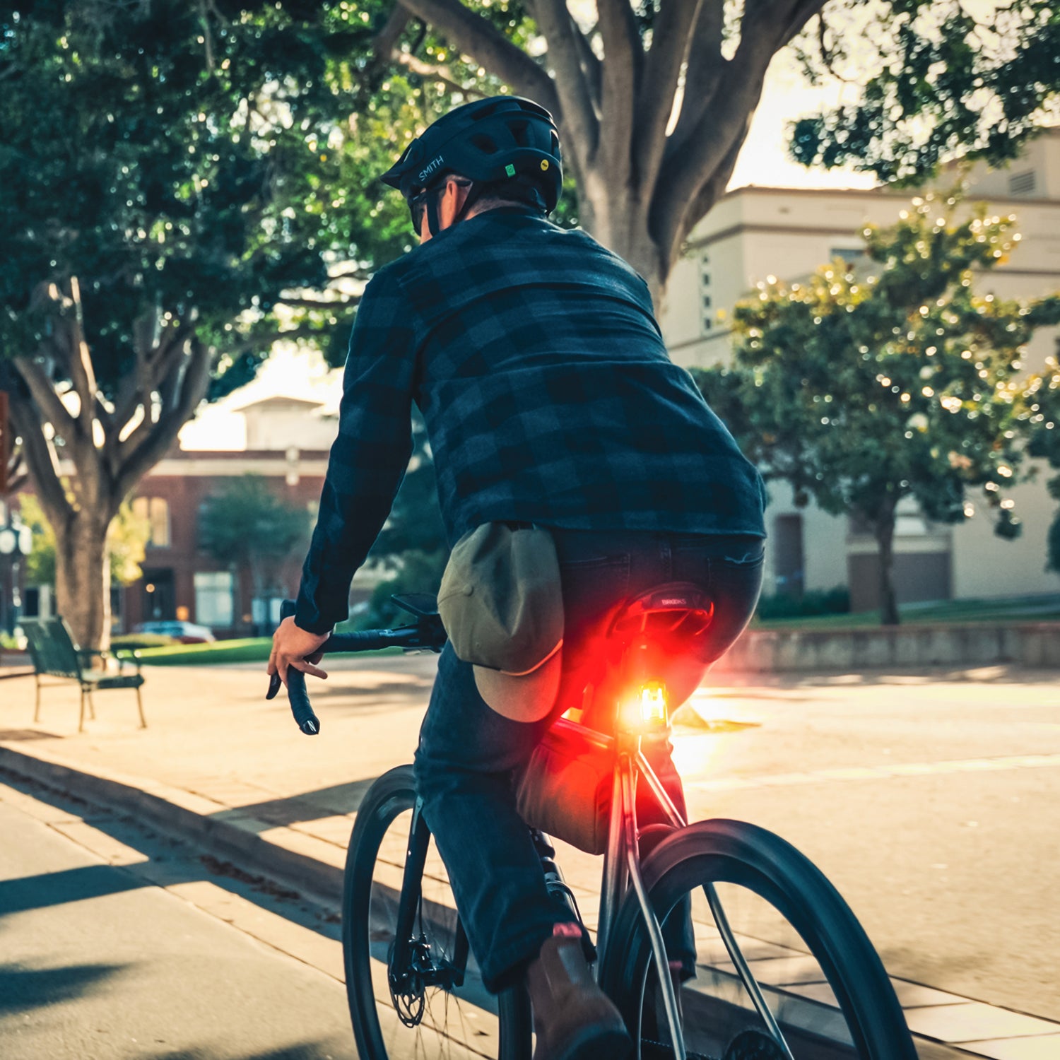 Back view of commuter with bright Lezyne Radar StVZO Rear visible in daylight, enhancing rider safety and visibility.