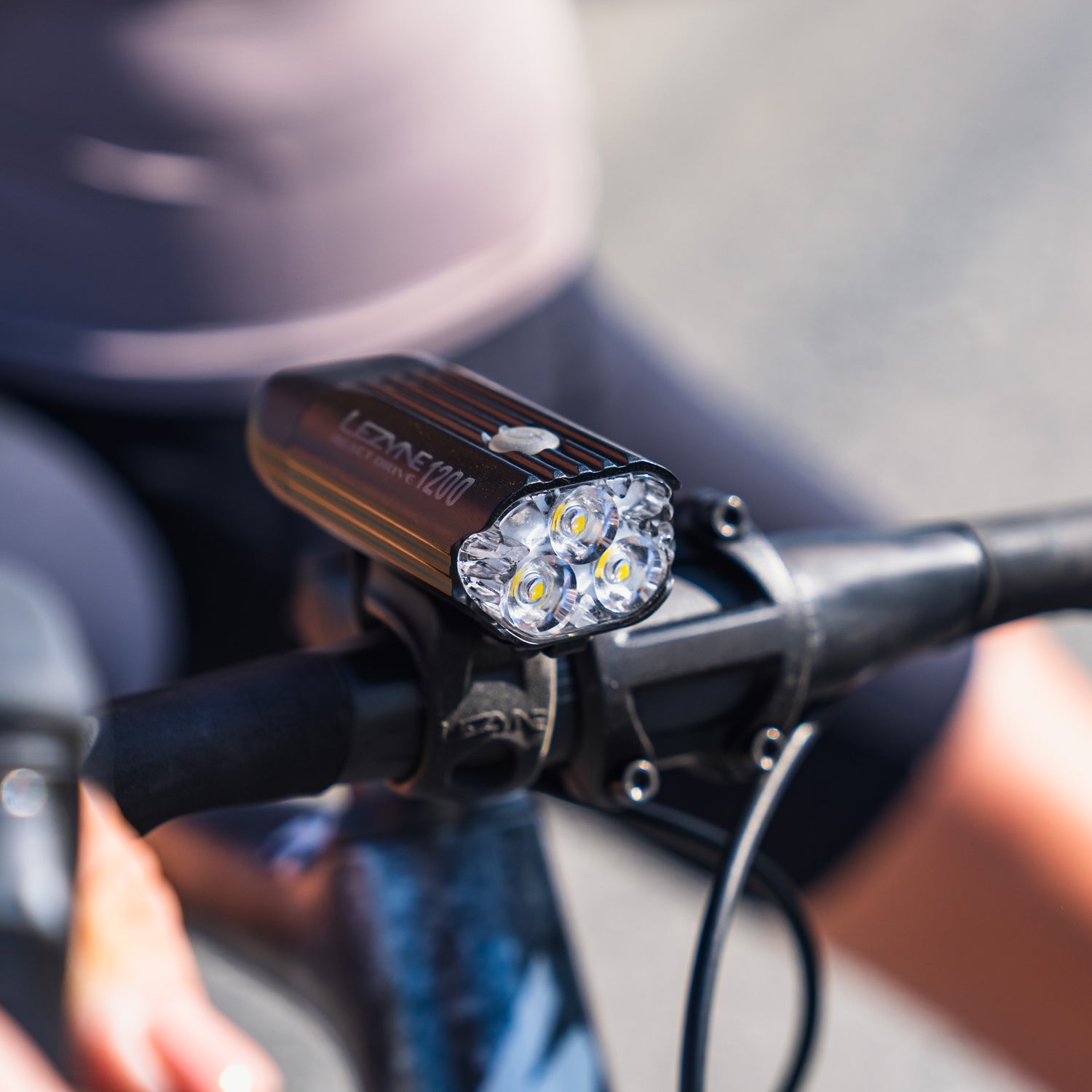 Lezyne React Drive LED front bike light on road bike in daylight; secure handlebar mount and compact body clearly visible thanks to disruptive daytime flash modes.