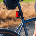 Lezyne Radar Drive LED rear bike light on road bike from side angle; sleek profile on aero post, outdoors in bright conditions.