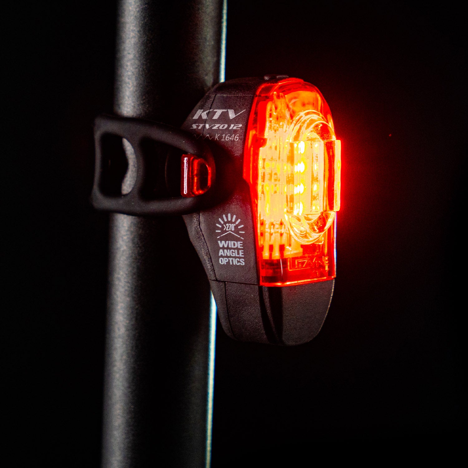 Close-up side view of the Lezyne KTV Drive StVZO Rear bike light, emitting a bright red light, mounted on the seat post.