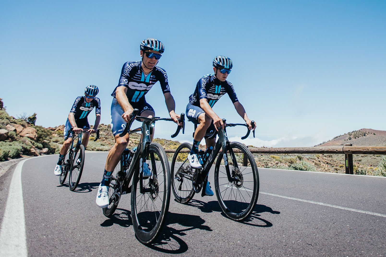 3 athletes from the french DSM team riding road racing style bicycles and wearing matching cycling outfits.