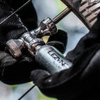 Mountain biker using silver Control Drive CO2 inflator on the trail, shown with threaded cartridge and twist valve control.